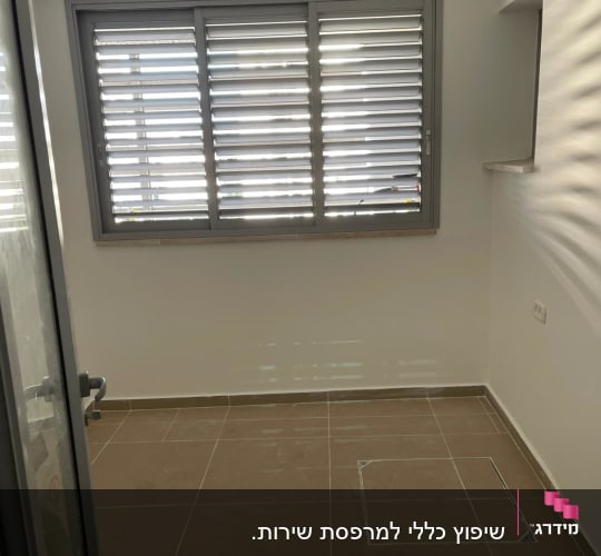 חדר עם רצפת אריחים חדשים וחלון עם תריסים